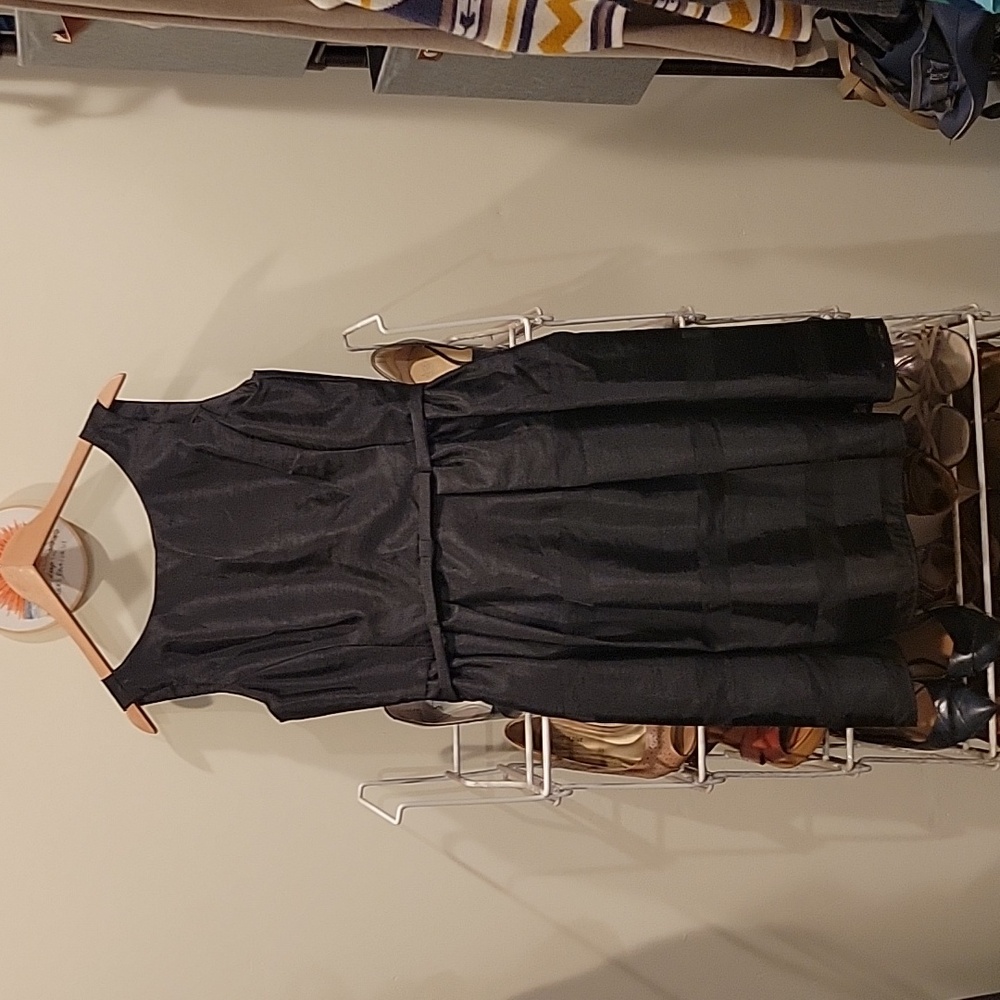 Black sleeveless party dress with back button accents.